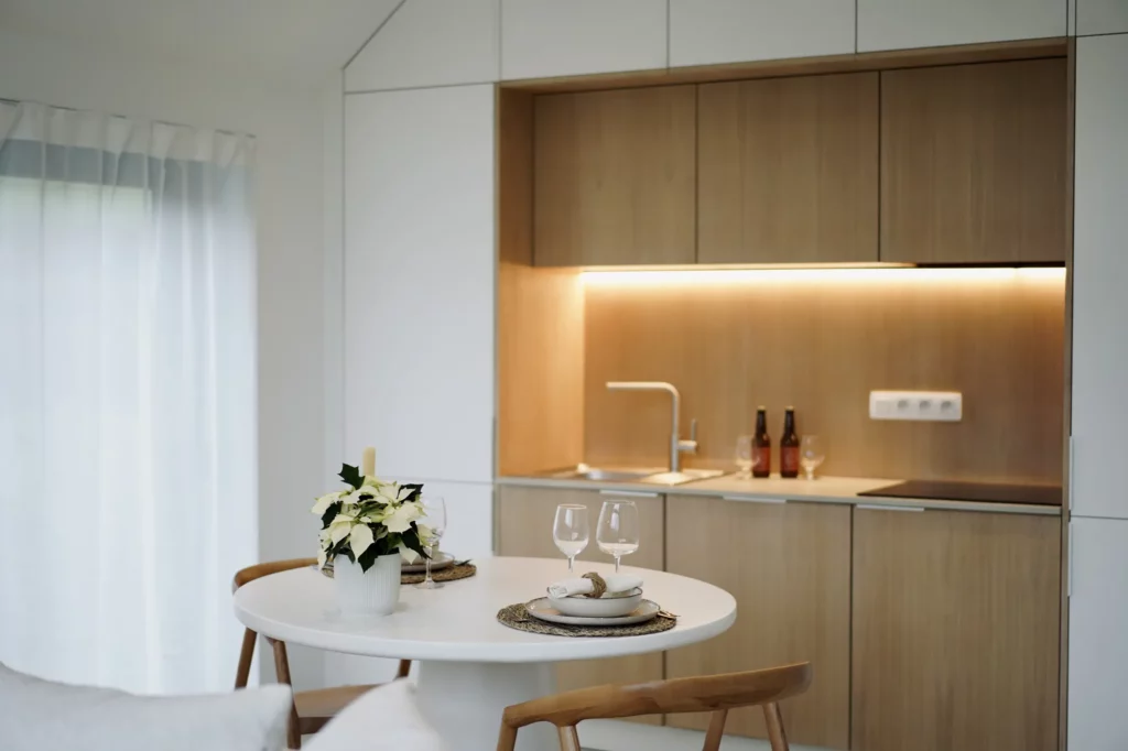 Cuisine équipée en bois clair avec éclairage chaleureux